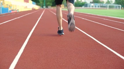 Sticker - Back view of a young man on a racetrack starting to run at stadium