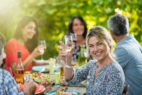 beautiful woman lunching with friends on a terrace table Poster