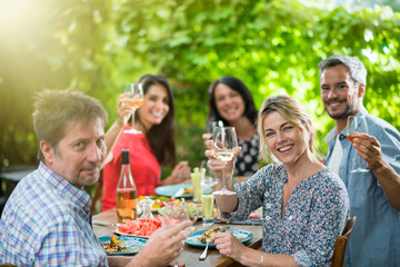 Group of friends toasting during a party on a terrace in summer