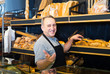 Portrait of  baker with fresh bread smiling in bakery