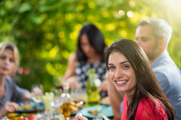 Poster - portrait of a woman sitting on a terrace sharing meal with frien