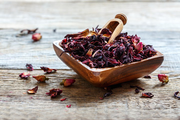 Wall Mural - Petals of hibiscus tea in a wooden bowl.