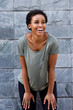 © mimagephotos - cool young black woman smiling with t-shirt against gray wall