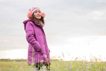 Young woman was playing in a field of flowers in the winter air.