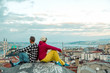 © alexbrylovhk - Man and Woman sitting on top of Roof City Building