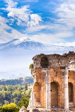 Ruins And Columns Of Antique Greek Theater In Taormina And Etna Mount In The Background. Sicily, Italy, Europe.