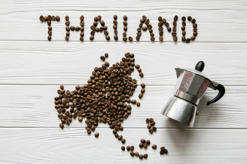 Wall Mural - Map of the Thailand made of roasted coffee beans laying on white wooden textured background with two cups of coffee and coffee maker