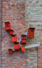 Red nesting boxes on brick wall - urban installation