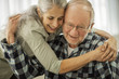 © Erickson Stock - Affectionate elderly couple share a spontaneous hug.