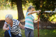 © Erickson Stock - Happy grandmother and granddaughter spraying a hose on a summer day.