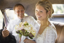 A Bride Sitting In A Car Holding A Bouquet