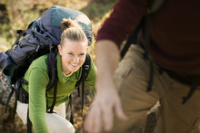 Portrait Of A Young Adult Woman Climbing With A Backpack Outside.