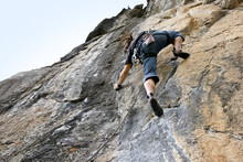 Man Reaching For The Next Hand Hold While Rock Climbing.