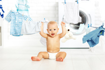 Wall Mural - fun happy baby boy to wash clothes and laughs in laundry