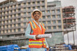 © Erickson Stock - Proud young female engineer holding a roll of building plans on a construction site.