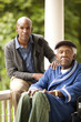 © Erickson Stock - Portrait of senior man and his adult son on verandah.