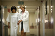 © Erickson Stock - Doctor helping patient to walk through the corridor after surgery