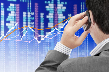 Fototapete - Man on a phone analyzing financial data and charts 