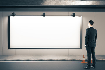 Businessman looking on blank billboard