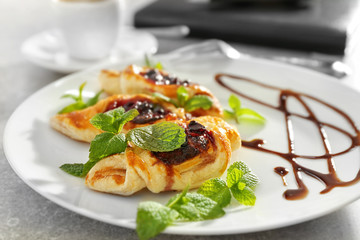 Poster - Plate with sweet tasty pastries on light background