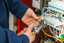 Electrician Stripping Ends Of Wires In Distribution Board, Closeup