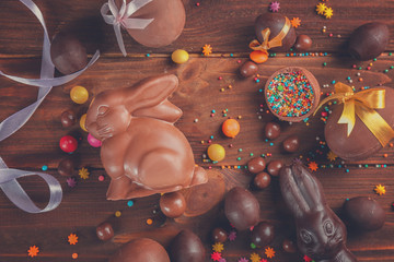 Canvas Print - Chocolate Easter bunny with eggs on wooden background