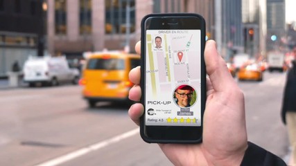 A man uses a ride-sharing app on his cellular phone to call a driver.	