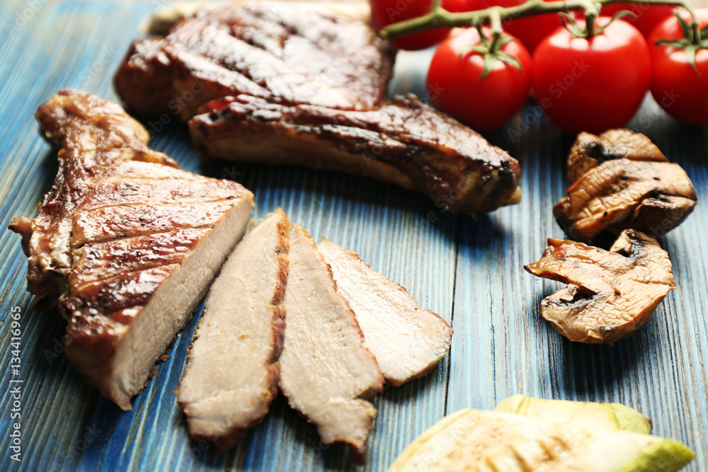 Grilled meat with vegetables on cutting board, closeup