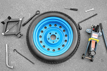 Wall Mural - Car wheel with tools on asphalt background