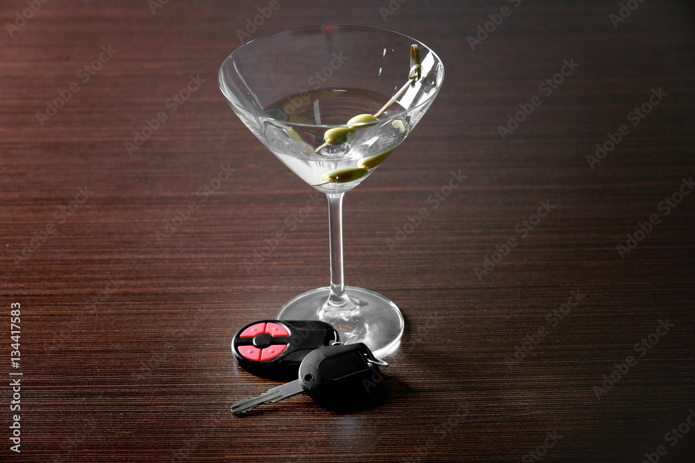 Glass of alcoholic beverage and car key on table. Don't drink and drive concept