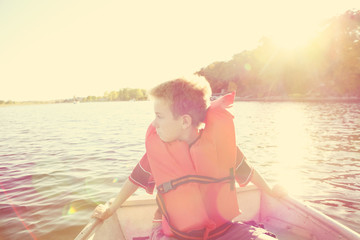 Boy riding in a  boat on a lake