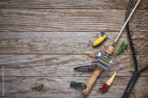 Fotografie, Obraz antique fishing lures, rod, and reel on a wood table
