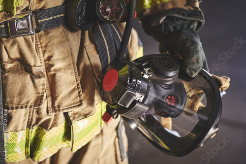 Fotomural a firefighter holding an oxygen mask