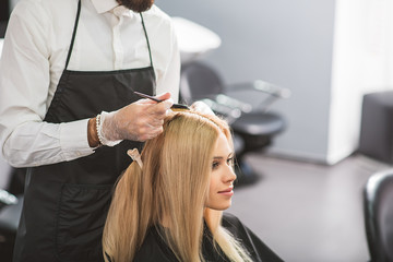 Wall Mural - Young woman is sitting at hairdressers