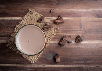 Sticker - Glass of chocolate milk on wood table,top view