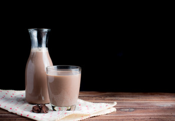 Sticker - Glass of chocolate milk on wood table,dark background