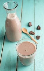 Sticker - Glass of chocolate milk on vintage wood background