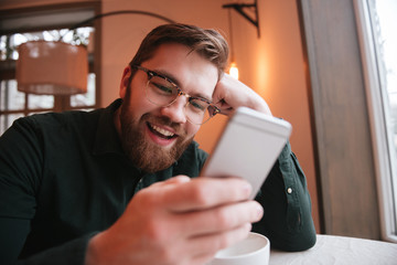 Poster - Happy bearded young man using smartphone.