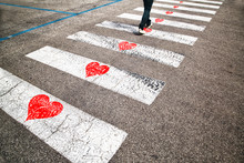 Pedestrian Road Crossing With Illustrated Red Heart Symbols On The Floor. Conceptual Man In Love On The Walk.