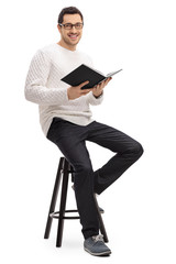 Sticker - Joyful guy with a book sitting on a chair