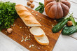 Crusty bread with vegetables on kitchen table. Ingredients for preparing tasty sandwiches with pumpkin, cucumbers and green. Snack, healthy food, vegetarian cuisine concept