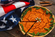 Pumpkin pie with american flag flat lay. Patriotic composition of national banner and traditional squash tart, Thanksgiving sweet. Seasonal meal, holiday, autumn, cooking concept