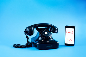 Vintage and modern phone isolated on blue background.