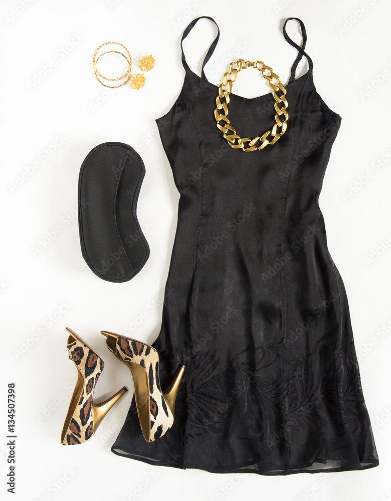 Christmas party outfit. Cocktail dress outfit, night out look on white  background. Little black dress, black clutch, leopard shoes, gold necklace,  bracelets and earrings. Flat lay, top view Stock Photo | Adobe