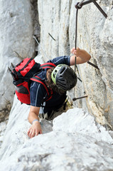 Mountaineer climbing up the steepy mountain in summer.