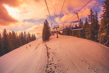 Winter Mountains Panorama With Ski Slopes And Ski Lifts In A Cloudy Day. Sunset Soft Light With Dramatic Orange Sky. Vintage Toning Effect. Bukovel, Carpathians, Ukraine, Europe