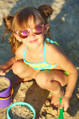 Canvas Print - Cute girl building sandcastle on beach