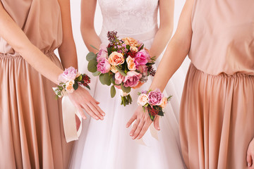 Wall Mural - Bride holding wedding bouquet and bridesmaids with beautiful boutonniere, closeup