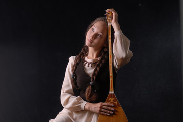 girl in national dress playing the komuz and jokes