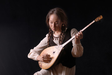 girl in national dress playing the komuz and jokes